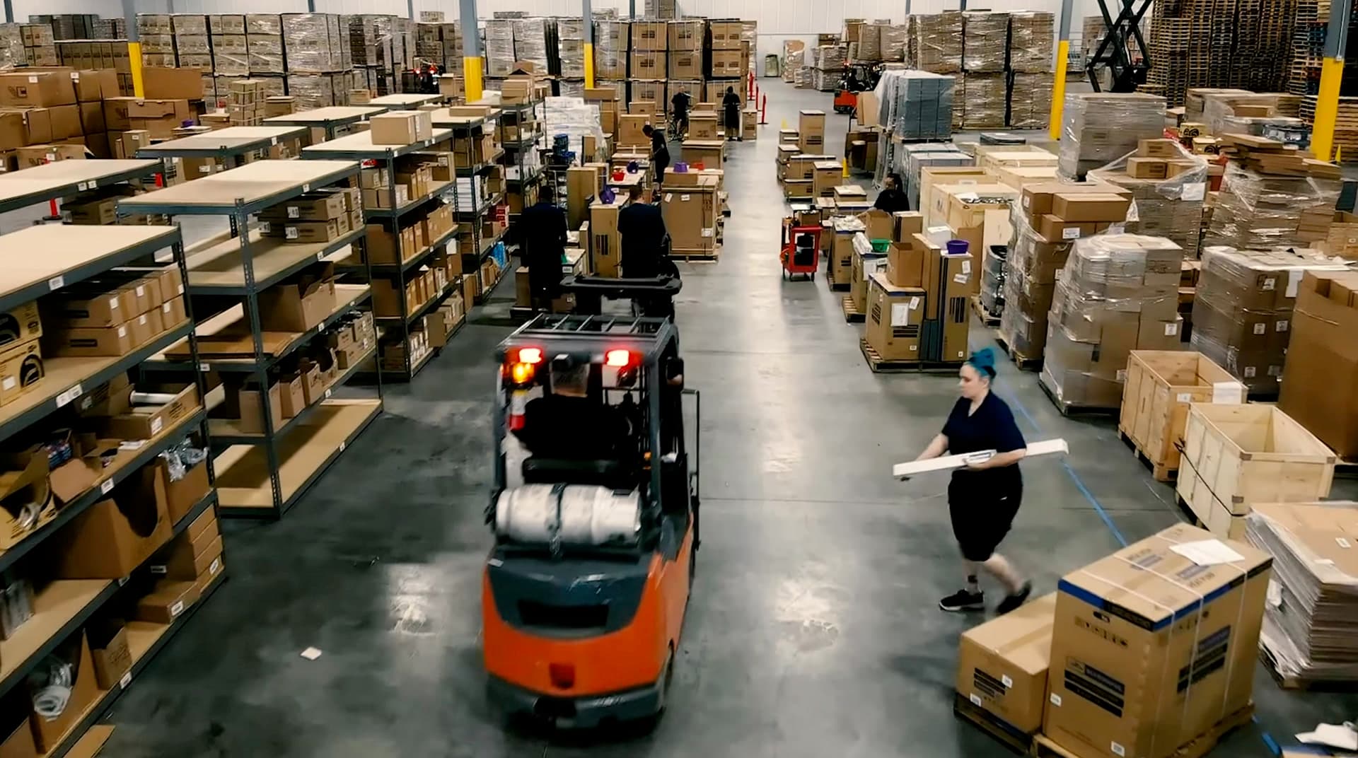 Alpine warehouse floor with forklift and team at work